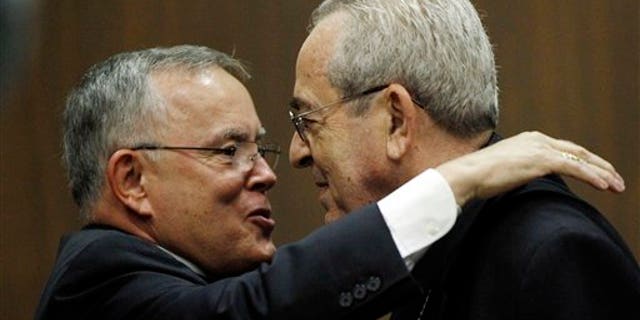July 19: Denver Archbishop Charles Chaput, left, and Cardinal Justin Rigali embrace during a news conference in Philadelphia.