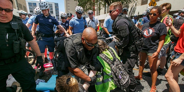 Police say seven protesters were issued citations for “failure to disperse” after they refused to let people in or out of a Philadelphia immigration office. (Jessica Griffin /The Philadelphia Inquirer via AP)