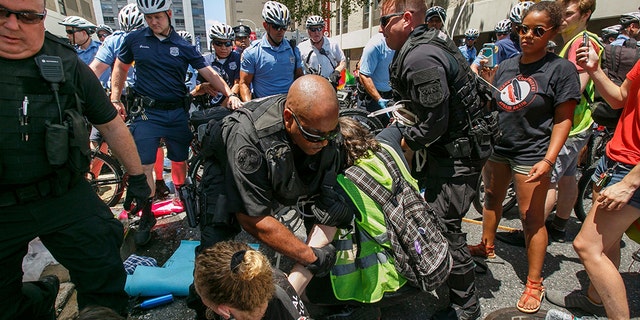 Police say seven protesters were issued citations for “failure to disperse” after they refused to let people in or out of a Philadelphia immigration office. (Jessica Griffin /The Philadelphia Inquirer via AP)