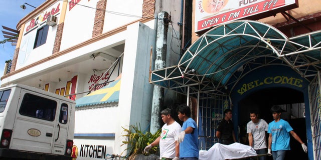 Jan. 11, 2013 - Funeral workers carry the body of a victim following a fire at a small 2-story hotel at Olongapo city, a former U.S. naval base, west of Manila, Philippines.