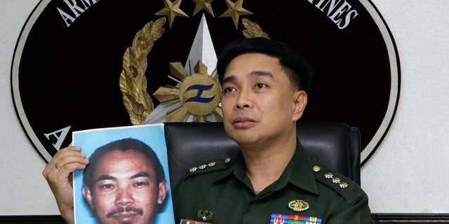 FILE - In this Feb. 2, 2012 file photo, then Armed Forces of the Philippines spokesman Col. Marcelo Burgos shows a picture of Malaysian Zulkifli bin Hir, also known as Marwan, during a press conference in suburban Quezon City, north of Manila, Philippines. Southeast Asia's top terrorist suspect has evaded capture and survived several military assaults in the southern Philippines, where police now await DNA results to confirm if he is the man killed in the Jan. 25, 2015 raid that also left 44 police commandos dead. (AP Photo/Pat Roque, File)