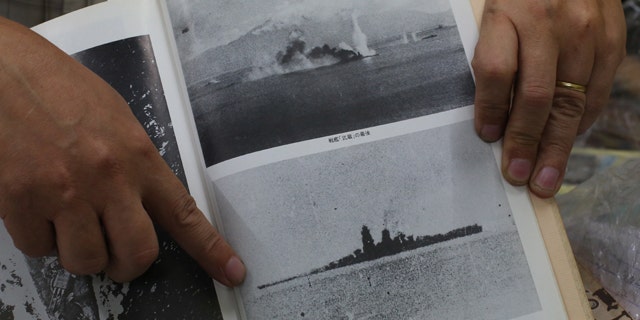 March 5, 2015: Filipino World War II historian Professor Rico Jose shows pictures before the Japanese World War II battleship Musashi sank as he talks to reporters at his office in suburban Quezon city, north of Manila. (AP Photo/Aaron Favila)