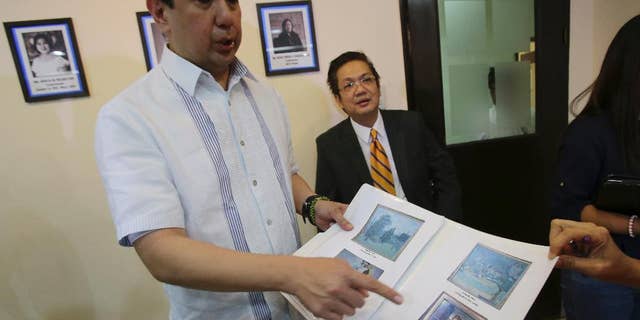 Andres Bautista, head of the Presidential Commission on Good Government, shows reporters some of the rare paintings of European masters that are allegedly part of the collection of the late dictator Ferdinand Marcos as he meets the press in suburban Mandaluyong city, east of Manila, Philippines on Wednesday, Oct. 1, 2014. Bautista says the Philippine government has seized at least 15 paintings from the former home of the Marcos, part of efforts to recover 156 artworks included in his alleged ill-gotten wealth. (AP Photo/Aaron Favila)