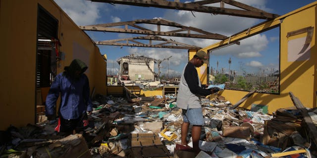 Dec. 9, 2013 - Typhoon survivor and district property custodian Norman Acala examines a book as he tries to save pieces from the school library at the Daniel Z. Romualdez Memorial Elementary School at typhoon-ravaged Tolosa town, Leyte province, central Philippines. Tens of thousands are living amid the ruins of their former lives, underneath shelters made from scavenged materials and handouts.