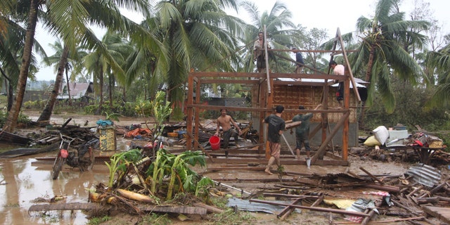 Dec. 4, 2012: Residents repair their damaged homes after Typhoon Bopha made landfall in Compostela Valley in southeastern Philippines.