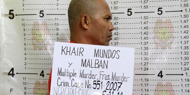 June 11, 2014: In this photo released by the Philippine National Police Public Information Office (PNP-PIO) in Manila, Philippines, Khair Mundos, a top commander of the Abu Sayyaf extremist group who is on the U.S. list of most-wanted terrorists and has acknowledged receiving Al Qaeda funds to finance bombings in the country, undergoes a police booking procedure following his capture near Manila's international airport. (AP Photo/Philippine National Police Public Information Office)