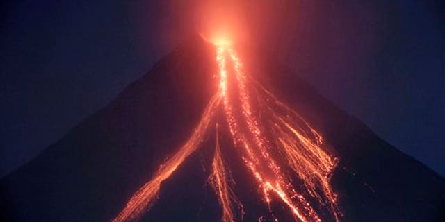 Lava cascades down the slopes of Mayon volcano in a continuing mild eruption as viewed from Legazpi city, Albay province, about 500 kilometers southeast of Manila, Philippines at dusk on Christmas eve Thursday Dec.24, 2009. Volcanologists warned that the weeklong moderate eruption of the 8,070-foot (2,460-meter) Mayon could escalate within days as the volcano belched out 20 grayish ash columns Thursday, some a mile (1.5 kilometers) high.