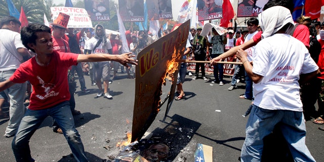 May 1, 2013: Protesters, mostly workers, burn a mural depicting U.S. President Barack Obama and Philippine President Benigno Aquino III after being blocked by police from getting closer to the U.S. Embassy in Manila to mark International Labor Day in Manila, Philippines. The workers, who have demanding wage increases for years, assailed Aquino for his Labor Day "gift" of non-wage benefits.