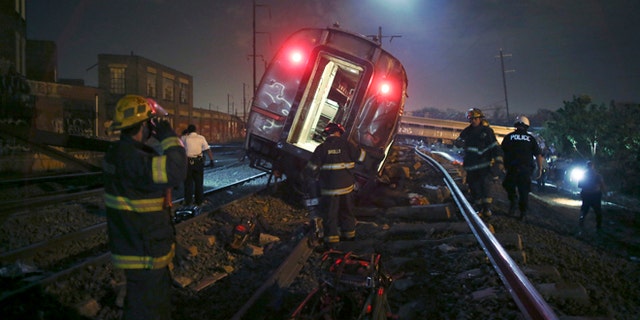 Emergency personnel work the scene of a deadly train wreck, Tuesday, May 12, 2015, in Philadelphia. An Amtrak train headed to New York City derailed and tipped over in Philadelphia. (AP Photo/ Joseph Kaczmarek)