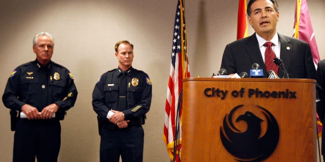 Phoenix Police Chief Jack Harris, left, listens during a news conference as Phoenix City Manager David Cavazos, right, talks about the shakeups announced in the police hierarchy at City Hall March 3 in Phoenix.