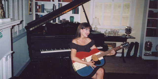 Victoria Hallman holding Buck Owens' guitar.