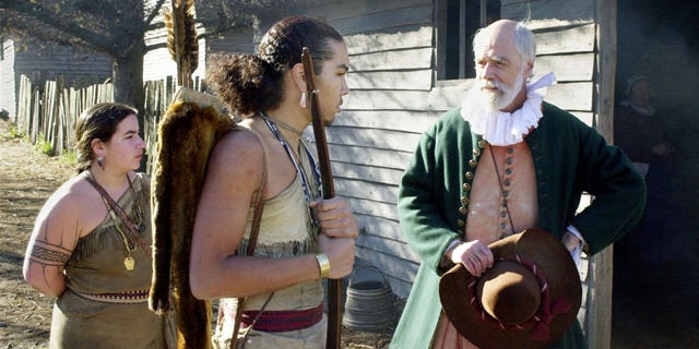 PLYMOUTH, MA - NOVEMBER 25: John Kemp (R) portrays pilgrim Steven Hopkins meeting with the colonists Wampanoag Indian interpreter Hobbamock, played by Jonathan Perry (C), as another Wampanoag, played by Melanie Roderick (L), looks on November 25, 2003 at Plimoth Plantation in Plymouth, Massachusetts. In real life, parents have the difficult job of teaching their children about the truth about what led to the holiday. (Photo by Michael Springer/Getty Images)