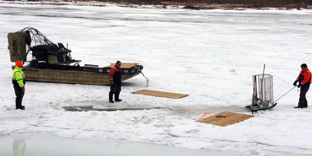 Jan. 19, 2015: Cleanup workers cut holes into the ice on the Yellowstone River near Crane, Mont, as part of efforts to recover oil from an upstream pipeline spill that released up to 50,000 gallons of crude. (AP Photo/Matthew Brown)
