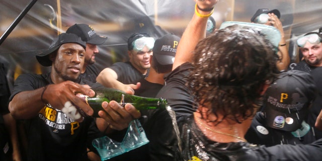 Pittsburgh Pirates left fielder Starling Marte, left, celebrates with teammates after the Pirates clinched a post season berth with a 2-1 win over the Chicago Cubs Monday, Sept. 23, 2013, in Chicago. (AP Photo/Charles Rex Arbogast)