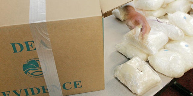 A U.S. Drug Enforcement Administration agent shows some of the 187 plus pounds of methamphetamine that was seized along with some 41 kilos of cocaine at a house in Gwinnett County on Aug. 16 during a DEA news conference in Atlanta, Monday, Aug. 21, 2006. Four defendants were also arrested and agents recovered a money counter, digital scales, and a large sum of suspected drug proceeds. (AP Photo/Ric Feld)