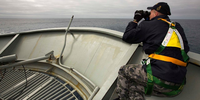 In this March 22, 2014 photo provided by the Australian Department of Defence (ADF), a lookout is stationed on bow of HMAS Success during the search in the southern Indian Ocean for signs of the missing Malaysia Airlines Flight MH370. The desperate, multinational hunt for Flight 370 resumed again Wednesday, March 26 across a remote stretch of the Indian Ocean after fierce winds and high waves that had forced a daylong halt eased considerably. (AP Photo/ADF, James Whittle) EDITORIAL USE ONLY