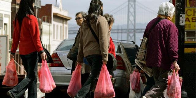 FILE: Women shoppers walk with plastic bags in the Chinatown district of San Francisco.