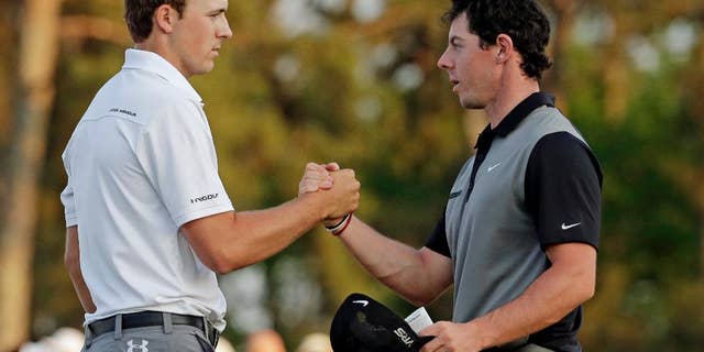 FILE - In this April 11, 2014, file photo, Jordan Spieth, left, shakes hands with Rory McIlroy, of Northern Ireland, on the 18th green following the second round of the Masters golf tournament in Augusta, Ga. The match that didn't happen in San Francisco will be available in stroke play at The Players Championship this week. Match Play winner Rory McIlroy, ranked No. 1, and Masters champion Jordan Spieth, ranked No. 2, are in the same group for the opening two rounds.(AP Photo/Charlie Riedel, File)