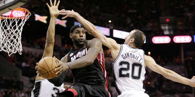 FILE - In this June 13, 2013 file photo, Miami Heat's LeBron James (6) passes between San Antonio Spurs' Boris Diaw (33), of France,  and Manu Ginobili (20), of Argentina, during the second half at Game 4 of the NBA Finals, in San Antonio.  A rematch of last year's thrilling NBA Finals finish is possible, but the Spurs and Heat would have to get through tough paths to get there. (AP Photo/Eric Gay, File)