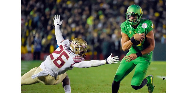 Jan. 1, 2015: Oregon quarterback Marcus Mariota, right, scores past Florida State defensive back P.J. Williams during the second half of the Rose Bowl NCAA college football playoff semifinal in Pasadena, Calif. (AP Photo/Mark J. Terrill)