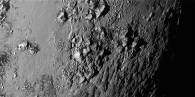 Tuesday, July 14, 2015 Image provided by NASA on Wednesday shows a region near Pluto's equator with a range of mountains captured by the New Horizons spacecraft.