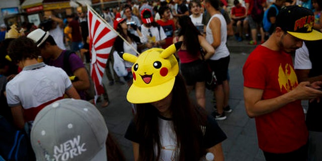 FILE - In this Thursday, July 28, 2016, file photo, fans play the highly addictive "Pokemon Go" game during a gathering in central Madrid, Spain, to play the computer game. Since debuting to wild adulation in the U.S., Australia and New Zealand this month, the game from Google spinoff Niantic Inc. has spread like wildfire, launching in more than 30 countries or territories, but not Brazil. For athletes and other visitors caught up in the wave, not having access is just one more knock against an Olympics that officials are racing to get ready. The opening ceremony takes place Friday, Aug. 5. (AP Photo/Daniel Ochoa de Olza, File)
