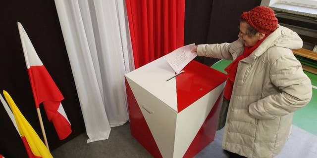 A woman casts her  ballot during the first round of Polish local elections, in Warsaw, Poland, Sunday, Nov. 16, 2014.  The voting is considered a test for the main parties ahead of the parliamentary elections next year. Some 30 million voters are eligible to choose nearly 47,000 councilors and 2,500 local administration leaders on Sunday, but observers are concerned about the possibility of a low turnout. Opinion polls gave a narrow lead to the governing pro-business Civic Platform party, over the nationalist opposition Law and Justice. (AP Photo/Czarek Sokolowski)