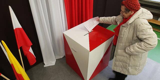 A woman casts her ballot during the first round of Polish local elections, in Warsaw, Poland, Sunday, Nov. 16, 2014. The voting is considered a test for the main parties ahead of the parliamentary elections next year. Some 30 million voters are eligible to choose nearly 47,000 councilors and 2,500 local administration leaders on Sunday, but observers are concerned about the possibility of a low turnout. Opinion polls gave a narrow lead to the governing pro-business Civic Platform party, over the nationalist opposition Law and Justice. (AP Photo/Czarek Sokolowski)