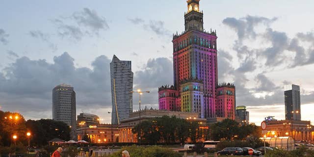 The communist era Palace of Culture, colorfully illuminated, is surrounded by modern skyscrapers, in Warsaw, Poland, Saturday, May 31, 2014. (AP Photo/Alik Keplicz)