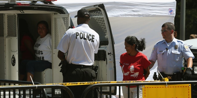 Police arrest demonstrators in front of the White House that were demanding that President Barack Obama halt deportations August 28, 2014 in Washington, DC. (Photo by Mark Wilson/Getty Images)