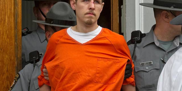 FILE - In this Oct. 31, 2014, file photo, Eric Frein, charged with the murder of Pennsylvania State Trooper Cpl. Byron Dickson and critically wounding Trooper Alex Douglass, is taken to prison after a preliminary hearing in Pike County Courthouse in Milford, Pa. On Thursday, Nov. 13, 2014, authorities added terrorism charges againstFrein and they say he told them he wanted to "wake people up." State police say Eric Frein called slaying of Cpl. Bryon Dickson an "assassination" in an interview after his capture. (AP Photo/The Scranton Times-Tribune, Michael J. Mullen, File)