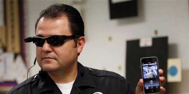 This Jan. 15, 2014 file photo shows Los Angeles Police Sgt. Daniel Gomez demonstrating a video feed from his camera into his cellphone as on-body cameras are demonstrated for the media in Los Angeles. Thousands of police agencies have equipped officers with cameras to wear with their uniforms, but theyve frequently lagged in setting policies on how theyre used, potentially putting privacy at risk and increasing their liability. As officers in one of every six departments across the nation now patrols with tiny lenses on their chests, lapels or sunglasses, administrators and civil liberties experts are trying to envision and address troublesome scenarios that could unfold in front of a live camera. (AP Photo/Damian Dovarganes)