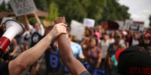 After listening to speakers in front of the St. Anthony Police Department, participants marched north on Silver Lake Rd. to 39th Ave. NE and then returned to where they started. A few hundred demonstrators protested peacefully on Silver Lake Rd. NE in front of the St. Anthony Police Department headquarters Sunday afternoon, July 10, 2016 in St. Anthony. (Jeff Wheeler/Star Tribune via AP)