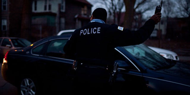 CHICAGO, IL - MARCH 12: A Chicago police officer directs traffic during a vigil for slain infant Jonylah Watkins on March 12, 2013 in Chicago, Illinois. The 6-month-old girl was shot five times on the 6500 block of South Maryland Avenue while her father was changing her diaper in the passenger seat of his car. The father, Jonathan Watkins remains is stable condition at Nothwestern Memorial Hospital after receiving three gunshot wounds.(Photo by Jonathan Gibby/Getty Images)