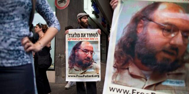 Israeli protesters hold posters demanding the release of Jonathan Pollard, a Jewish American who was jailed for life in 1987 on charges of spying on the United States, as they stand outside the U.S. embassy in Tel Aviv, Israel, Sunday, June 19, 2011. Israelis are rallying behind convicted spy Jonathan Pollard like never before, urging the U.S. on Sunday to let the former Pentagon analyst leave prison to attend his father's funeral.