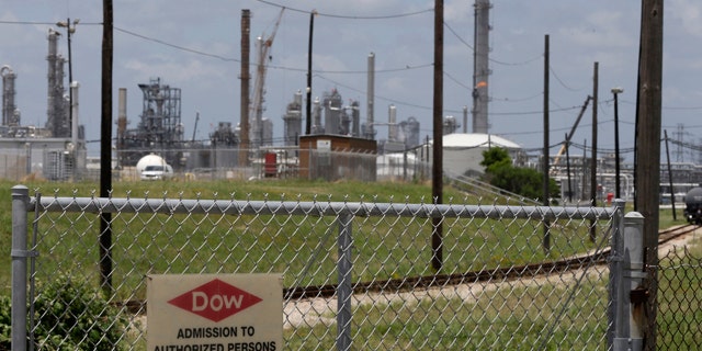 May 22, 2014: A sign is posted on a roadside fence outside a Dow Chemicals plant in Freeport, Texas. (AP Photo/Pat Sullivan)