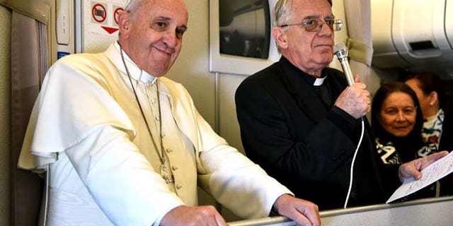 Jan. 19, 2015: Vatican spokesman Rev. Federico Lombardi, right, flanked by Pope Francis, talks with journalists during the flight from Manila to Rome. (AP/Giuseppe Cacace, pool)