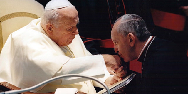 In this undated file photo, Archbishop of Buenos Aires Jorge Mario Bergoglio, now Pope Francis, kisses the hand of Pope John Paul II during a ceremony at the Vatican.