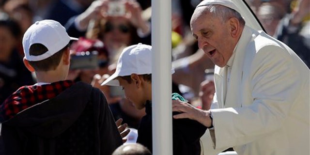 Pope Francis greets 11-year-olds Livio Bastianelli and Davide Maria Bianchi Wednesday, April 16, 2014.