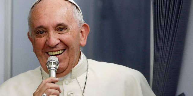In this photo taken on Sunday, July 12, 2015, Pope Francis smiles as he meets the media during an airborne press conference aboard the airplane directed to Rome, at the end of his Apostolic journey in Ecuador, Bolivia and Paraguay. (AP Photo/Gregorio Borgia)