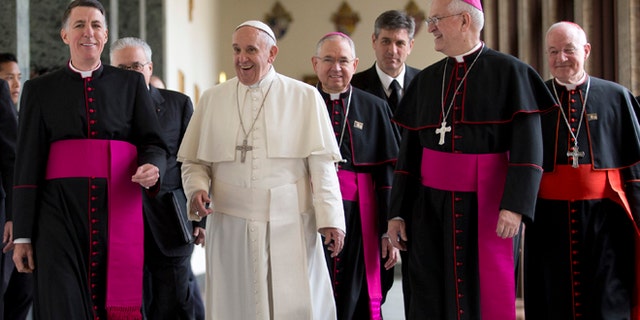 Pope Francis, flanked by rector of the Pontifical North American College James F. Checchio, left, Cardinal Marc Ouellet, right, and President of the United States Conference of Catholic Bishops Joseph Edward Kurtz arrives at Rome's Pontifical North American College, Saturday, May 2, 2015. Pope Francis has praised the "holiness" and "zeal" of an 18th-century Franciscan missionary he'll make a saint when he visits the United States this fall but whom Native Americans in California contend brutally converted indigenous people to Christianity. Francis on Saturday praised the accomplishments and qualities of Rev. Junipero Serra during a homily at a Rome seminary training future priests from North America. (AP Photo/Andrew Medichini)