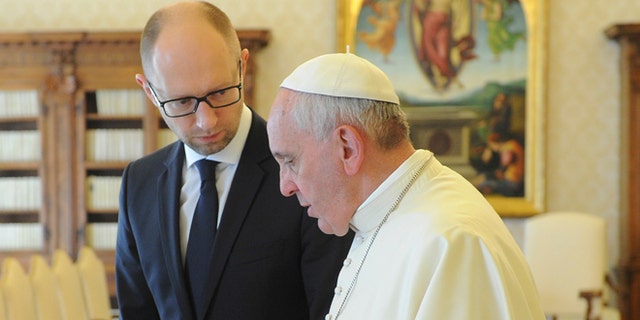 Ukrainian Prime Minister Arseny Yatsenyuk, left, listens to Pope Francis on the occasion of their private audience at the Vatican, Saturday, April 26, 2014. Yatsenyuk is in Rome to attend Sunday's canonization ceremony for John Paul II and John XXIII where Pope Francis will elevate the two popes to sainthood. (AP Photo/Andrew Kravchenko, Pool)
