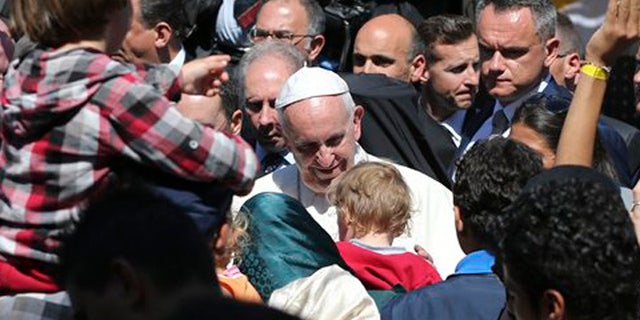 Pope Francis meets migrants at the Moria refugee camp on the Greek island of Lesbos, Saturday April 16, 2016. Pope Francis travelled Saturday to Greece for a brief but provocative visit to meet with refugees at a detention center as the European Union implements a controversial plan to deport them back to Turkey. (AP Photo/Petros Giannakouris)