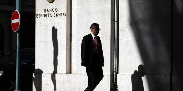 A man walks past a Portuguese bank Banco Espirito Santo's building in downtown Lisbon, Friday July 11, 2014. Senior Portuguese officials gave assurances Friday about the soundness of Portugal's biggest bank, seeking to defuse tension after world markets went into a spin over fears that Banco Espirito Santo's troubles could reignite Europe's financial difficulties. (AP Photo/Francisco Seco)