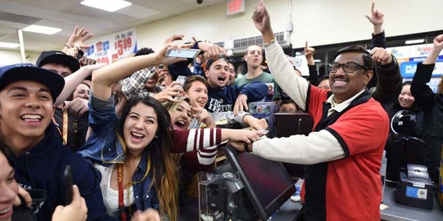 7-Eleven store clerk M. Faroqui celebrates with customers after learning the store sold a winning Powerball ticket on Wednesday, Jan. 13, 2016 in Chino Hills, Calif. One winning ticket was sold at the store located in suburban Los Angeles said Alex Traverso, a spokesman for California lottery. The identity of the winner is not yet known. (Will Lester/The Sun via AP) MANDATORY CREDIT