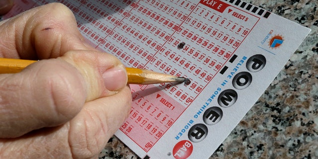 FILE - In this Jan. 12, 2016 file photo, a lottery player fills out numbers on a powerball form in Oakland, Calif. The Powerball jackpot has grown to over 1.5 billion dollars. Only ne ticket matched all six numbers in the drawing Saturday, May 7, for a $429.6 million jackpot, said Powerball spokeswoman Kelly Cripe, and New Jersey lottery officials said Sunday it was sold at a 7-Eleven store in Trenton, N.J. (AP Photo/Ben Margot, File)