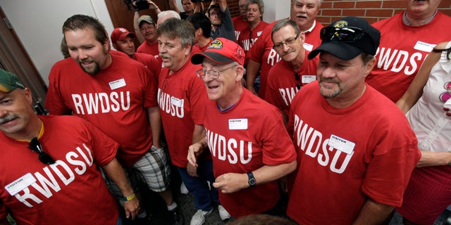June 20, 2012: Workers from the Quaker Oats plant in Cedar Rapids, Iowa, look on as their winning $241 million Powerball ticket is scanned at the Iowa Lottery headquarters in Des Moines, Iowa.