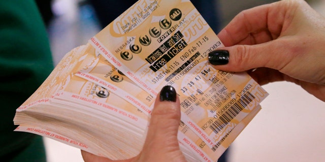 A lottery representative hands out free Powerball tickets at Russ's Market in Lincoln, Neb., as part of a promotion, Wednesday, Feb. 11, 2015. The Powerball jackpot has climbed to an estimated $500 million, which would make it the fifth largest lottery prize in U.S. history.