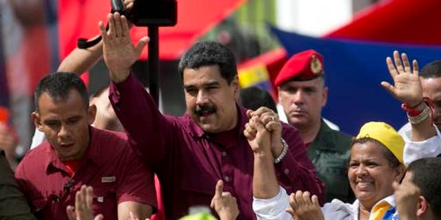 Venezuela's President Nicolas Maduro waves to supporters during a rally outside Miraflores presidential palace in Caracas, Venezuela, Friday, Oct. 28, 2016. For the most part, residents of Venezuela's capital ignored calls to stay home Friday to protest Maduro, handing a rare victory to the embattled leader. (AP Photo/Ariana Cubillos)