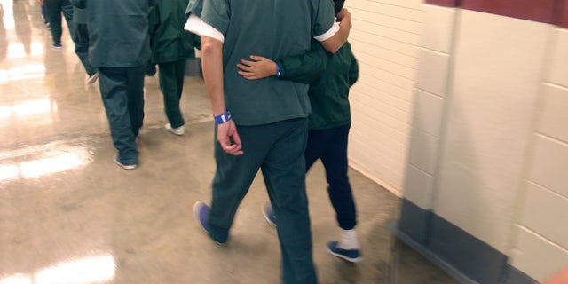 A Feb. 9, 2007 file photo provided by the Department of Homeland Security shows family detainees walking down the hall at the T. Don Hutto Residential Center in Taylor, Texas. (AP Photo/Department of Homeland Security, Charles Reed, HO, File)